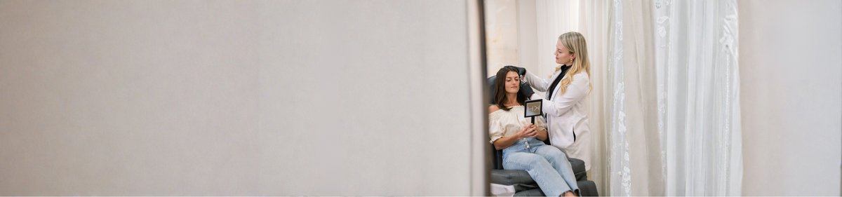Woman receiving a hair treatment in a salon with a neutral background